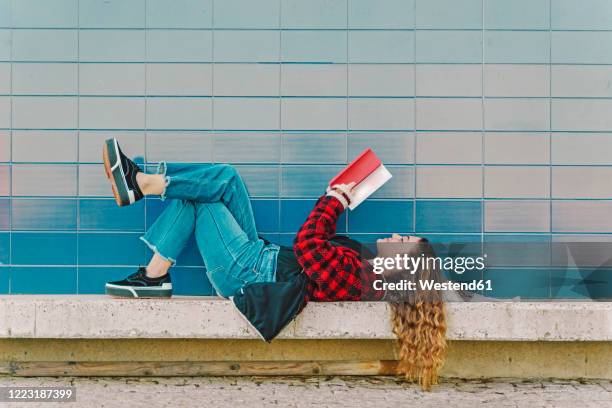 teenage girl reading book outdoors - teenagers reading books stock pictures, royalty-free photos & images