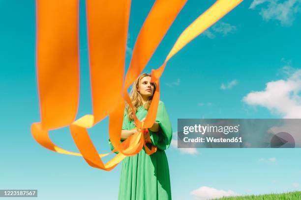 young woman wearing a green dress holding orange ribbons - green day band bildbanksfoton och bilder