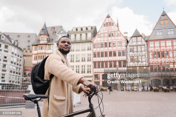 portrait of stylish man with a bicycle in old town, frankfurt, germany - germany landmark stock pictures, royalty-free photos & images