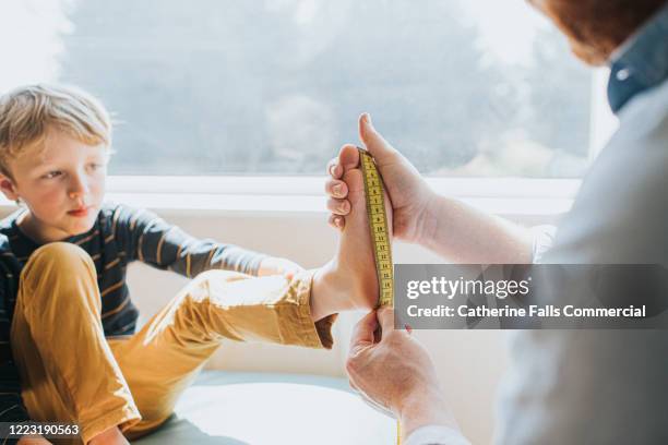 measuring child's foot - longitud fotografías e imágenes de stock