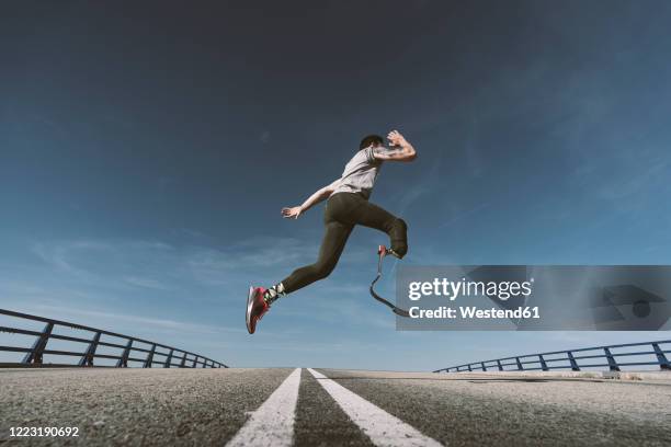 disabled athlete with leg prosthesis exercising on a road - artificial limb stock pictures, royalty-free photos & images