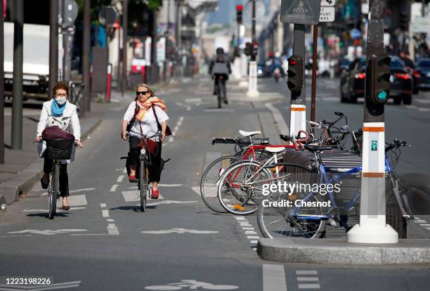 Women ride their bicycles in a cycle lane in the "Rue de Rivoli" as the lockout continues due to the epidemic of coronavirus on May 06, 2020 in...