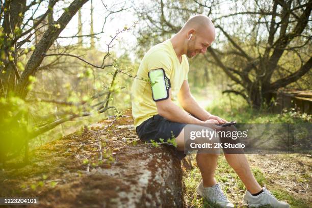 ein mann mittleren alters geht im wald joggen, dehnt sich und macht fitnesstraining - 2k resolution stock-fotos und bilder