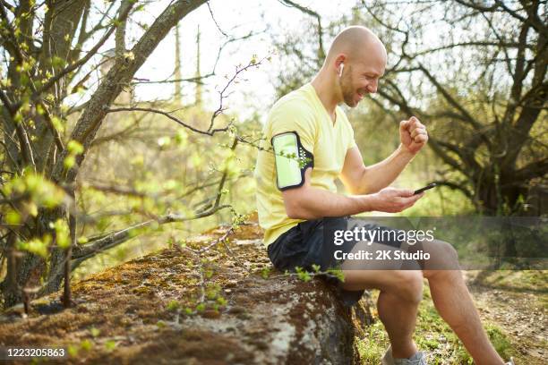 ein mann mittleren alters geht im wald joggen, dehnt sich und macht fitnesstraining - 2k resolution stock-fotos und bilder