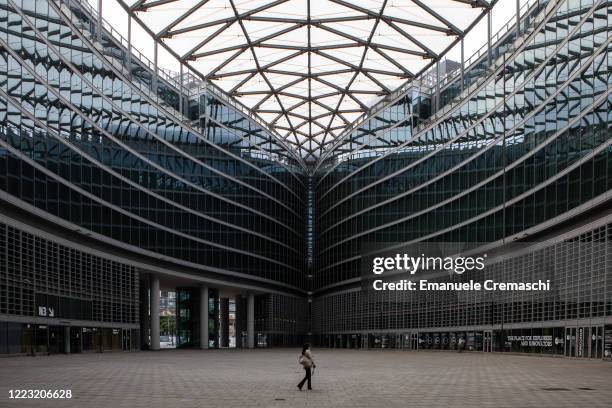 Woman, wearing a protective face mask, walk in a square surrounded by Lombardy Region's HQ building on May 06, 2020 in Milan, Italy. Italy was the...