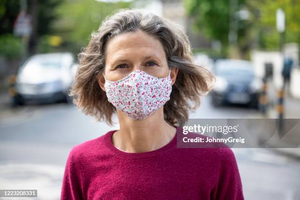 portrait of woman wearing face mask outdoors - protective face mask stock pictures, royalty-free photos & images
