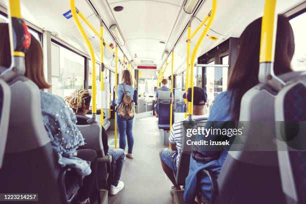 back view of passengers commuting by public transport - vehicle interior stock pictures, royalty-free photos & images