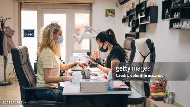 women enjoying manicure in beauty salon during covid-19 - nail salon stock pictures, royalty-free photos & images