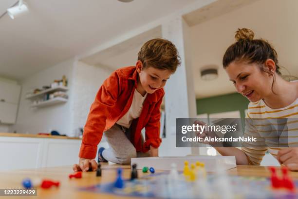 mother and son playing board game ludo at home - game board stock pictures, royalty-free photos & images