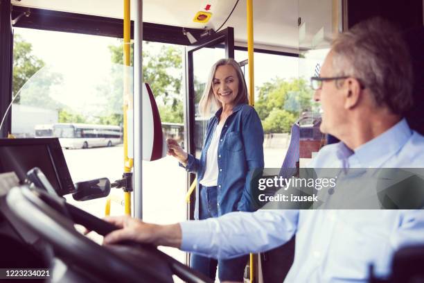 非接触支払いを通じて運賃を支払うシニア女性 - バス運転手 ストックフォトと画像