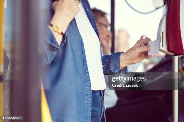 woman paying fare through contactless payment - fare stock pictures, royalty-free photos & images