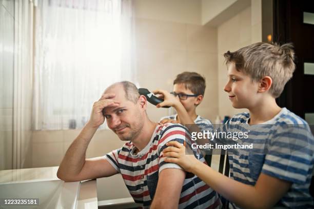 petits garçons ayant l’amusement coupant les cheveux de leur père - bad haircut photos et images de collection