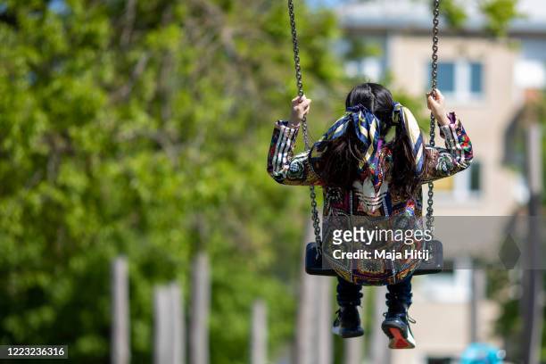 Girl swings at re-opened playground during the coronavirus crisis on May 06, 2020 in Berlin, Germany. Germany is relaxing its lockdown measures...