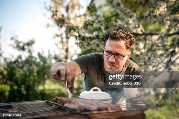 ajout d’une pincée d’assaisonnement pour un meilleur goût - burger on grill photos et images de collection