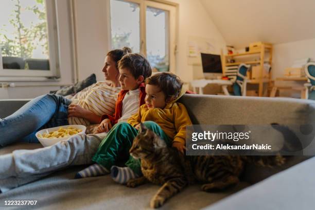 relajarse en casa - familia viendo la television fotografías e imágenes de stock