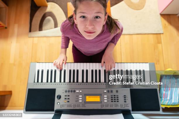 girl playing piano at home - keyboard musical instrument child stock pictures, royalty-free photos & images