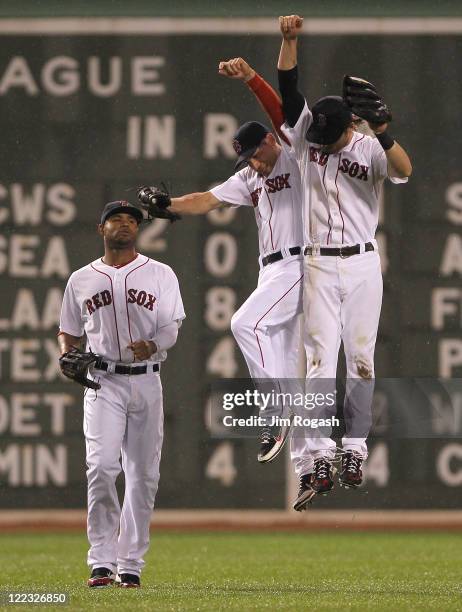 Carl Crawford, Jacoby Ellsbury, and Josh Reddick of the Boston Red Sox celebrate a 4-0 win over the Oakland Athletics at Fenway Park August 27, 2011...