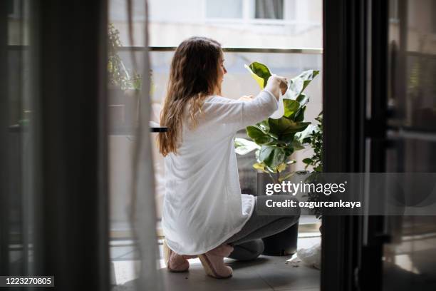 schöne hausfrau mit blume im topf und gartenset - frau balkon stock-fotos und bilder