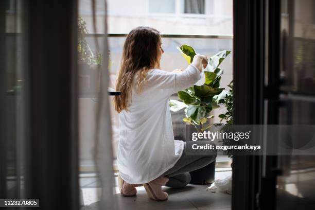 encantadora ama de casa con flor en maceta y conjunto de jardinería - balcon fotografías e imágenes de stock