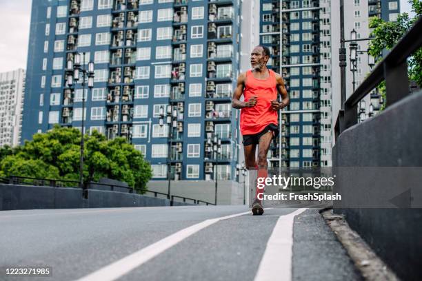 erholung in den 50er jahren: senior man running in the city - black stockings stock-fotos und bilder