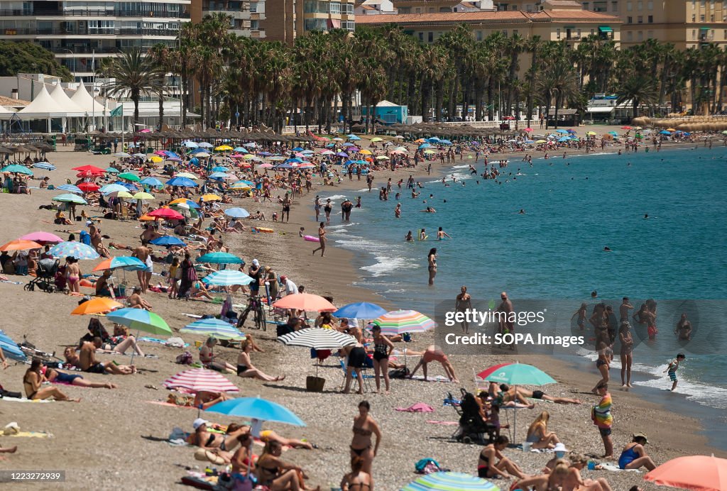 People sunbathing at La Malagueta beach during a hot summer...