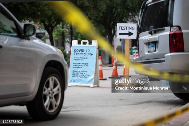 Cars wait in line at a drive up COVID-19 testing site inside the American Airlines Center parking garage in Dallas on June 27, 2020. Dallas County...