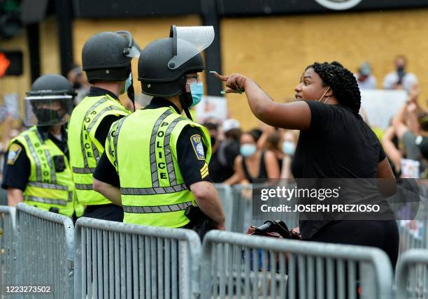 Women argues with police officers during a pro-police and Trump rally, organized by the group Super Happy Fun America, outside the State House in...