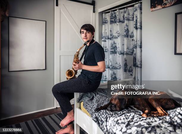 teenager playing sax in his room - boxer dog playing stock pictures, royalty-free photos & images