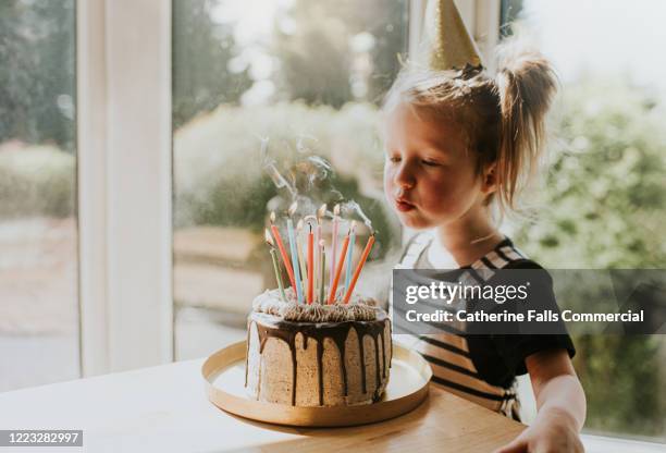 blowing out candles - happy birthday cake stock-fotos und bilder