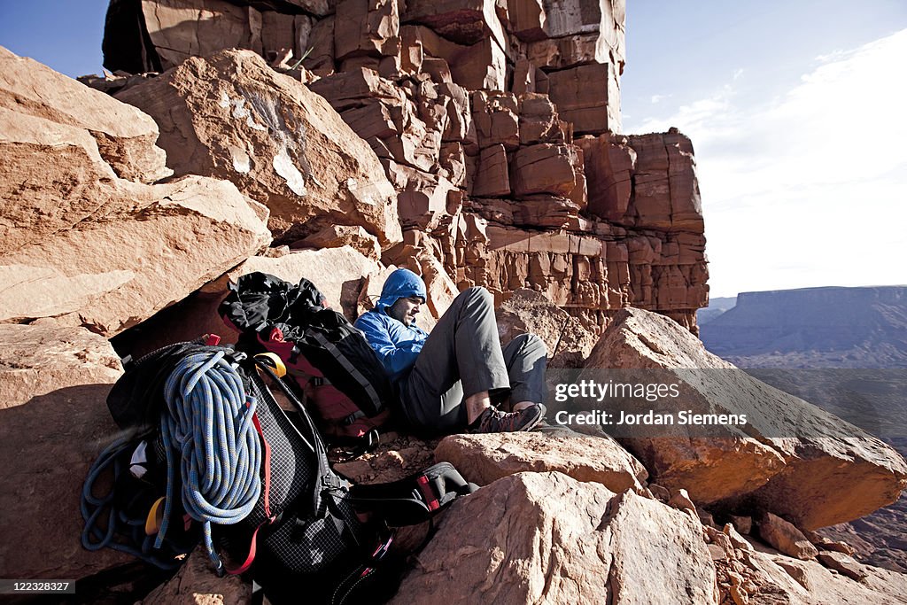 Rock climber sitting at base of climb.