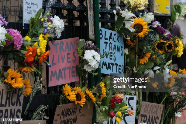 Flowers and placards are left attached to the railings at Westminster tube station after thousands of transgender people and their supporters marched...