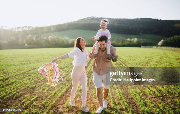 happy young family with small toddler girl on a walk in spring nature. - fashionable family stock pictures, royalty-free photos & images