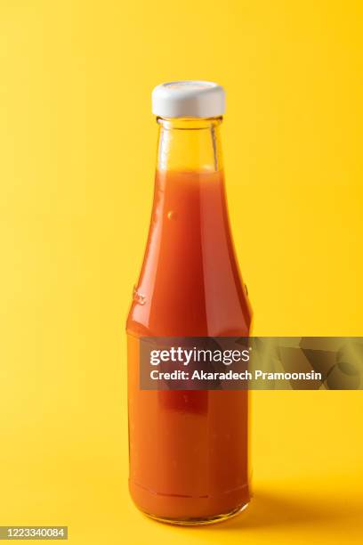 flavoring: chili sauce on a yellow background - sauce stockfoto's en -beelden