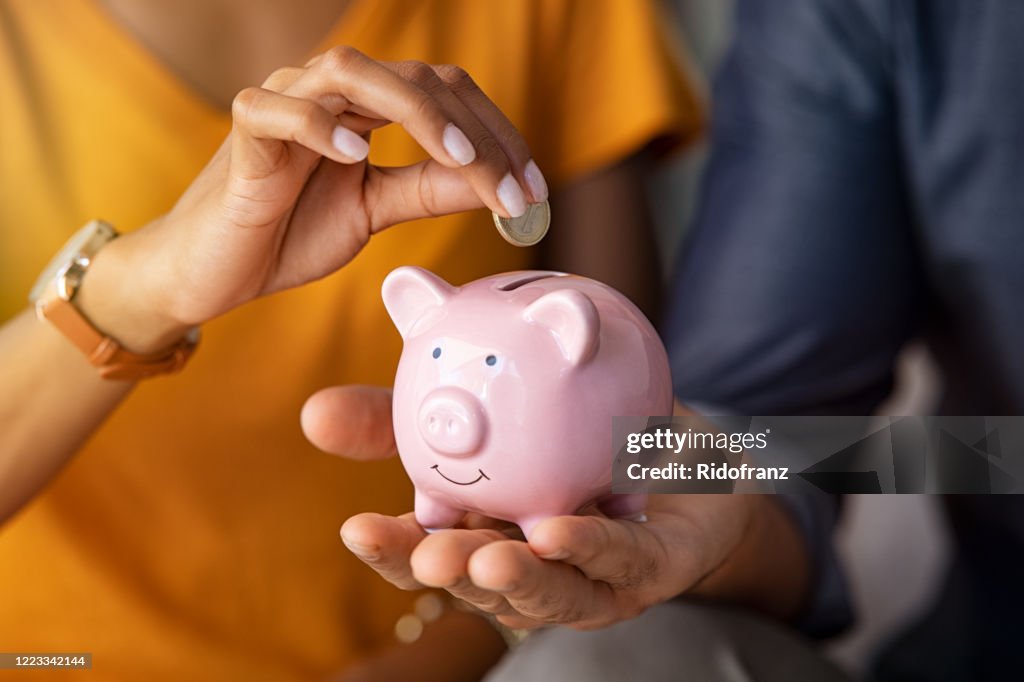 Couple saving money in piggybank