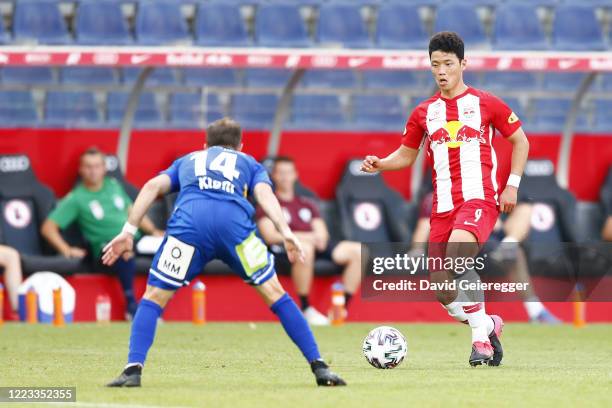 Christian Klem of Hartberg challenges Hee Chan Hwang of Salzburg during the tipico Bundesliga match between Red Bull Salzburg and TSV Prolactal...