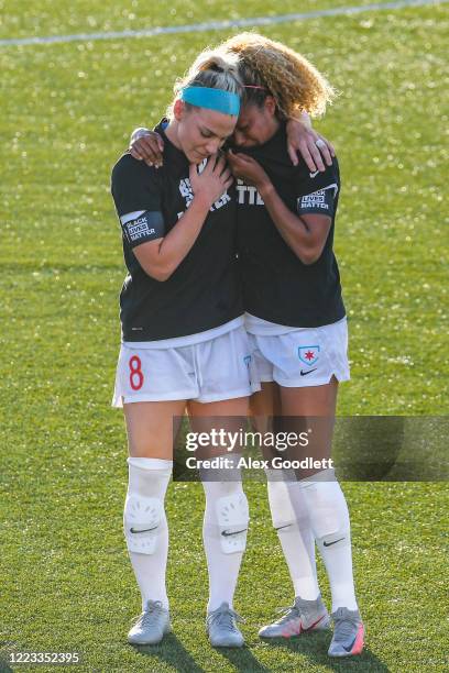 Julie Ertz holds Casey Short of the Chicago Red Stars react after the playing of the national anthem prior to a game against the Washington Spirit in...