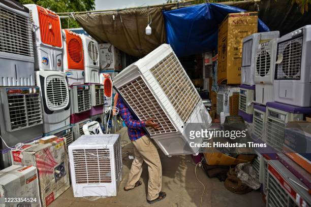 Shop worker sets up air coolers on a hot summer day at Kamla Market, on June 28, 2020 in New Delhi, India.