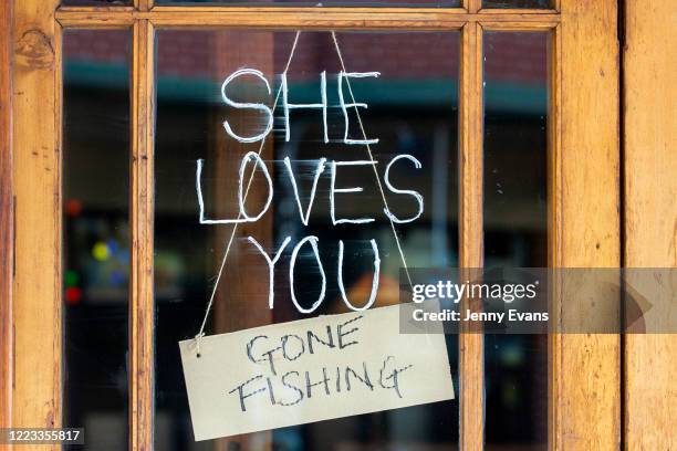 Gone fishing sign is displayed in the window of a shop in Newtown on May 07, 2020 in Sydney, Australia. Some retailers are starting to reopen with...