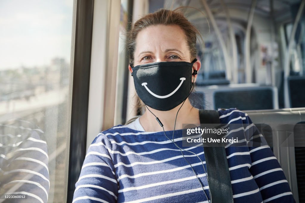 Mature woman wearing protective mask on train