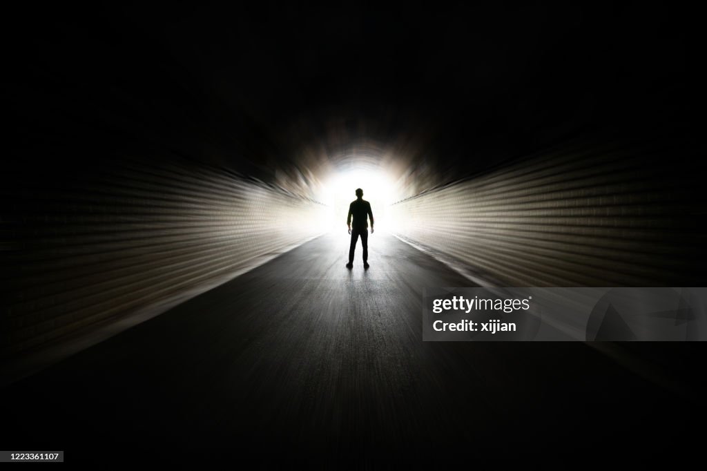 Man walking in dark tunnel