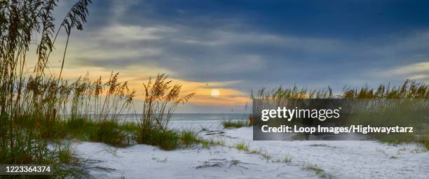 panoramic view of sun setting over holmes beach in florida - anna maria island stock-fotos und bilder