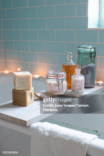 bath with bath salts in glass jars and natural soaps - bath salt stock pictures, royalty-free photos & images