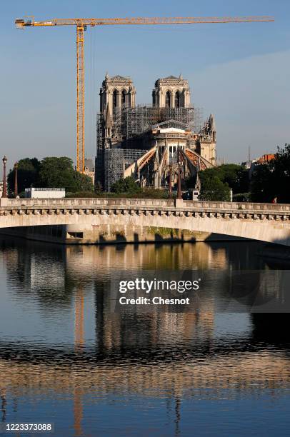 Notre-Dame Cathedral and "Pont de la Tournelle" bridge are reflected in the still waters of the Seine river at daybreak as the lockdown continues due...