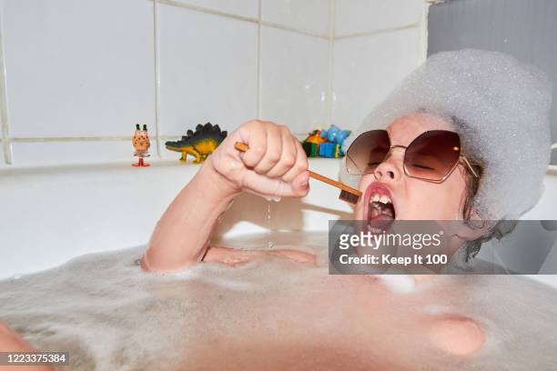 child singing in bubble bath - humor stockfoto's en -beelden