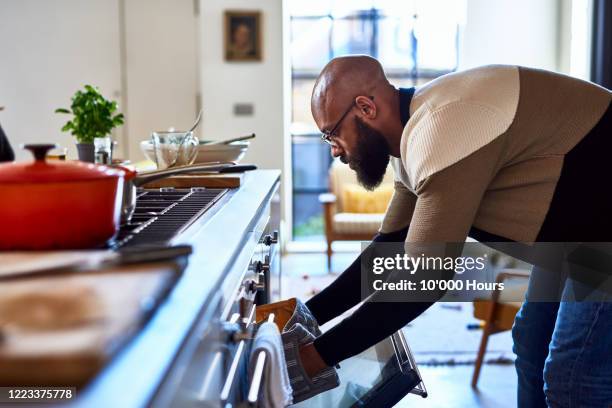 man making dinner and opening oven - hob 個照片及圖片檔