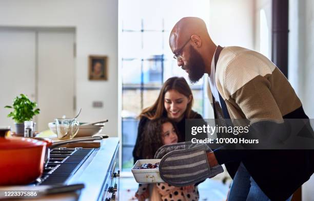 father making dinner with mother and daughter at home - familie warm stock pictures, royalty-free photos & images