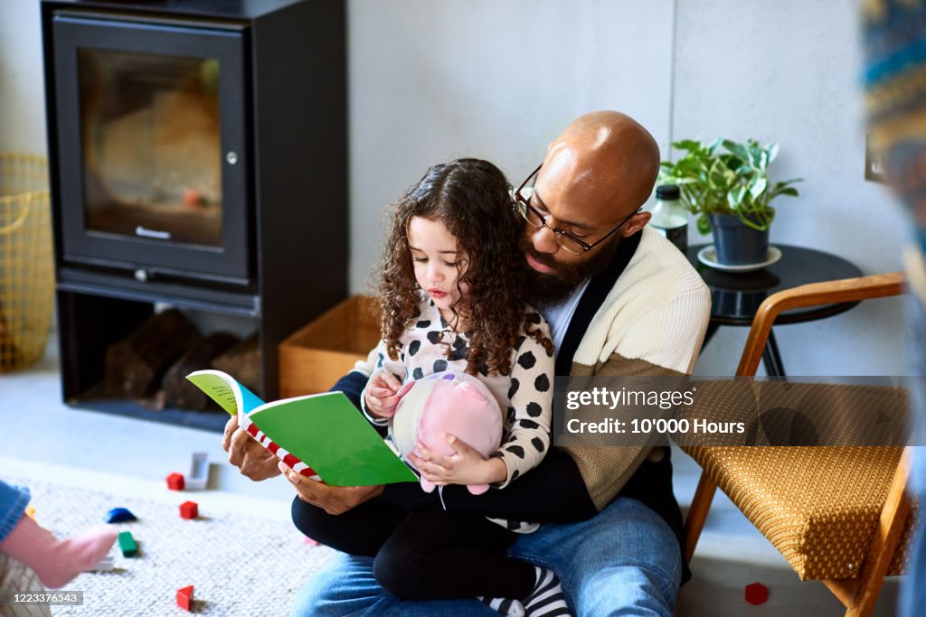 Man reading story book with daughter