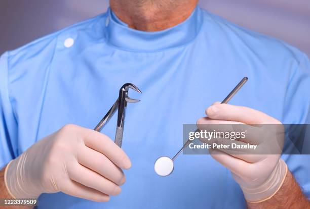 dentist ready to extract troublesome tooth - dentist phobia stock-fotos und bilder