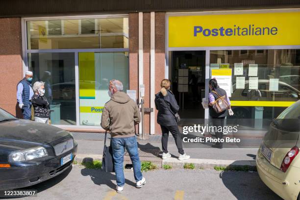 some people wait in line to enter a post office in rome during the covid-19 emergency - post office stock pictures, royalty-free photos & images