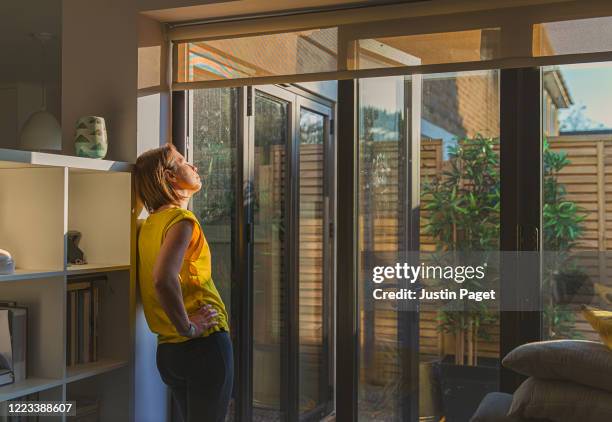 woman standing by her back door - yellow door stock pictures, royalty-free photos & images